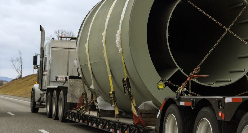 truck pulling a large piece of equipment on a trailer