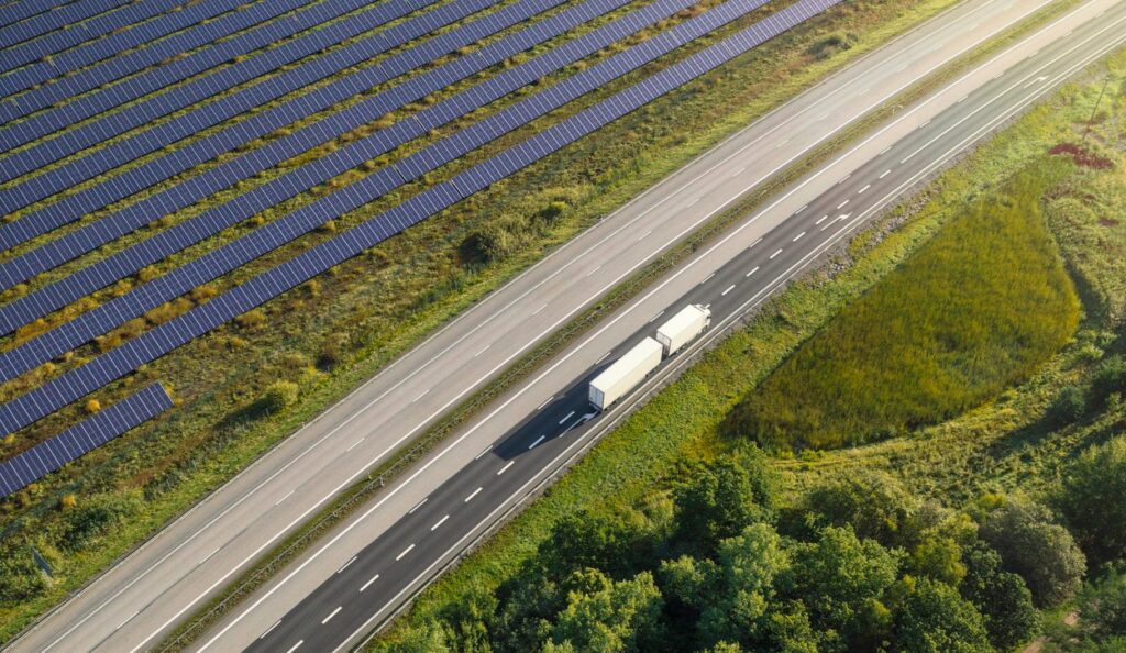 Delivery trucks driving by utility-scale solar farm