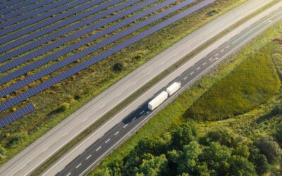 Delivery trucks driving by utility-scale solar farm