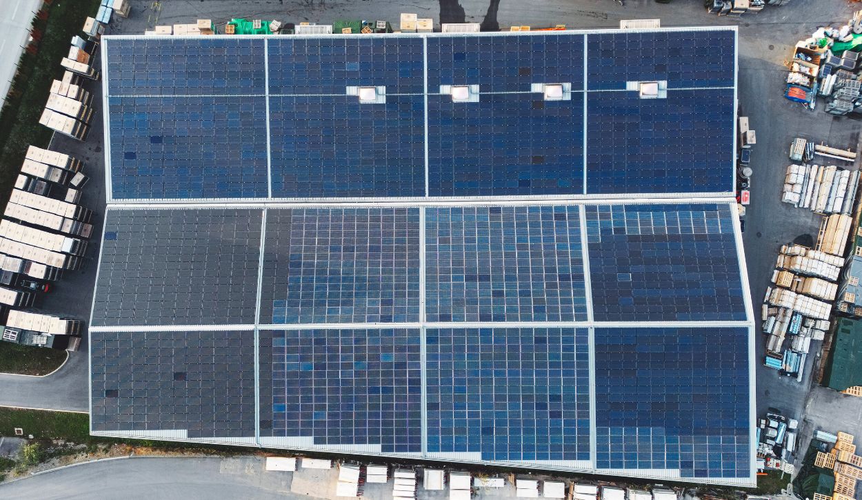 Aerial view of warehouse covered in solar panels