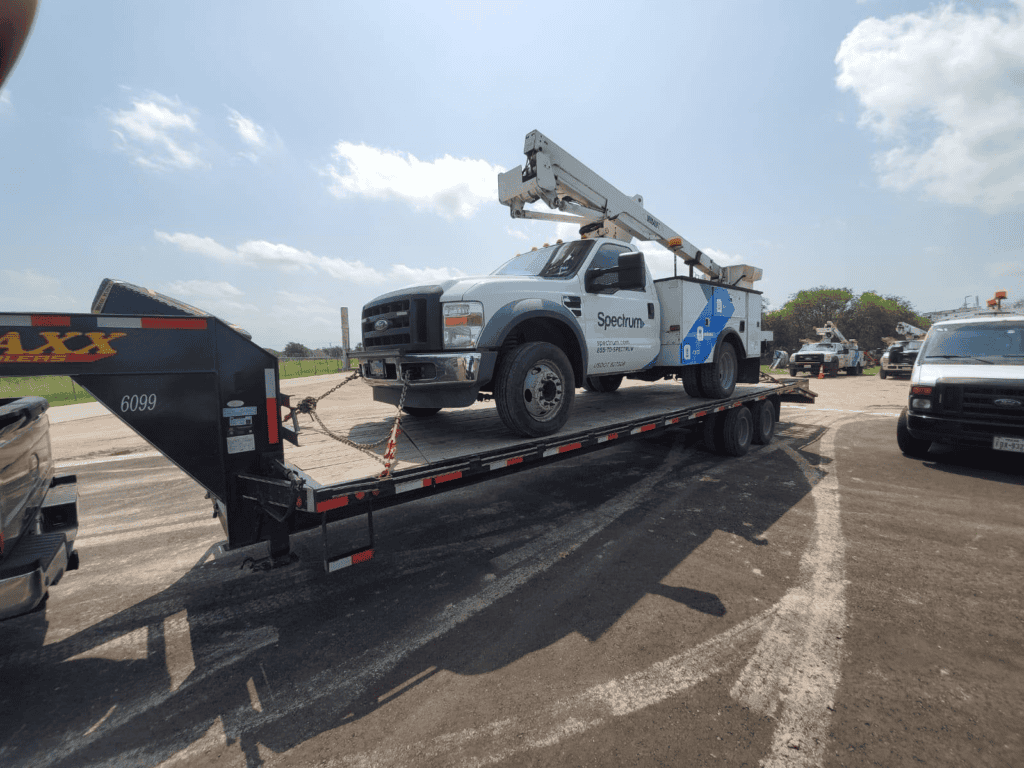 Spectrum utility truck loaded on flatbed trailer truck